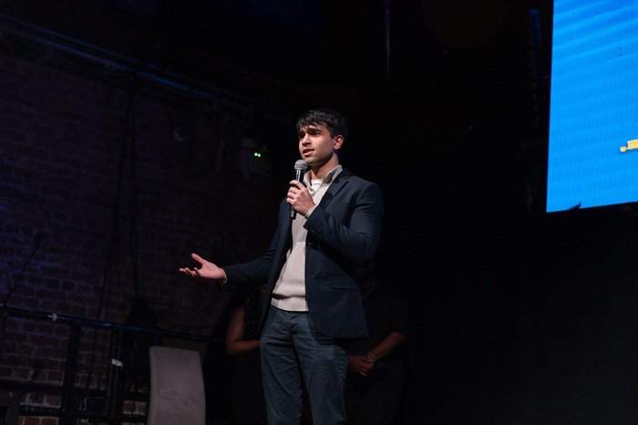 Young Ambassador, Krish holding a microphone and speaking on stage