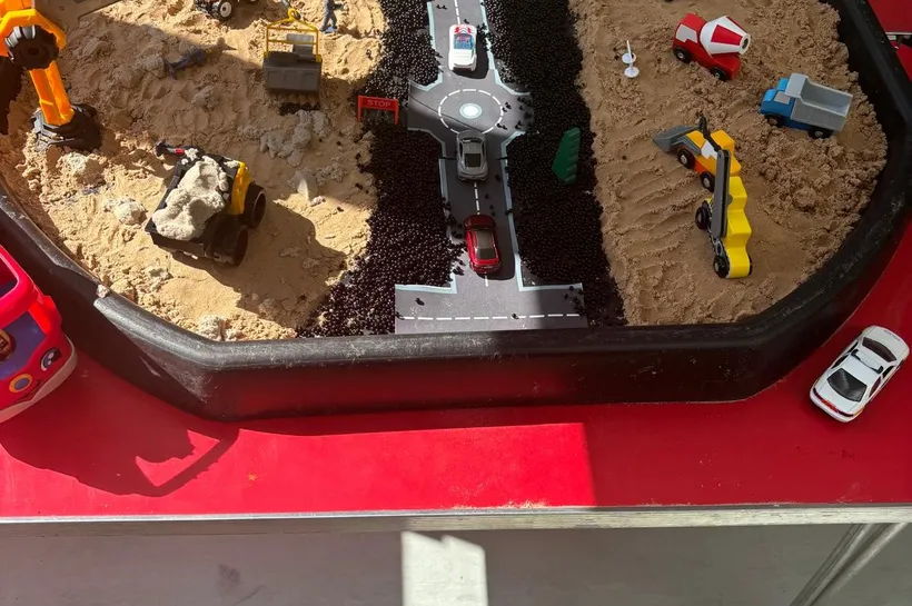 A tuff tray filled with sand and a building site scene