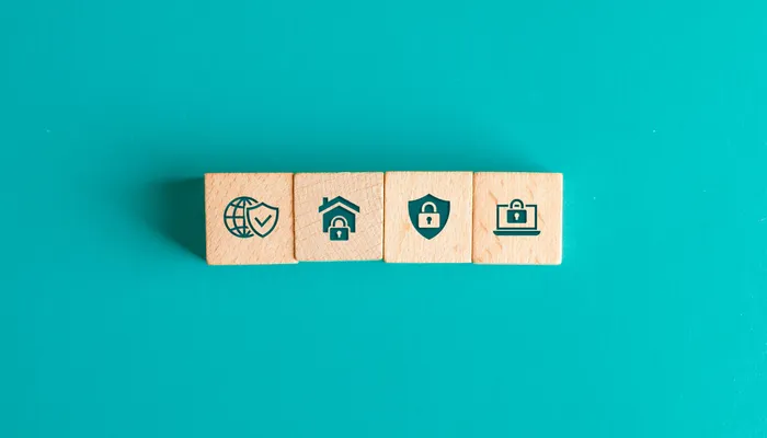 Security concept with icons on wooden blocks on turquoise table flat lay.