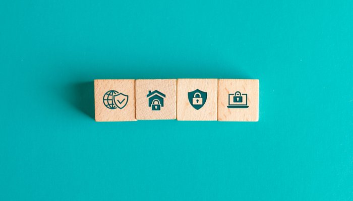 Security concept with icons on wooden blocks on turquoise table flat lay.