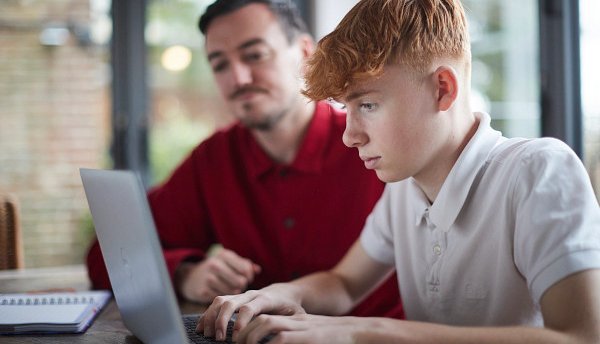 Young person in care studying with their carer