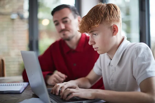 Young person in care studying with their carer