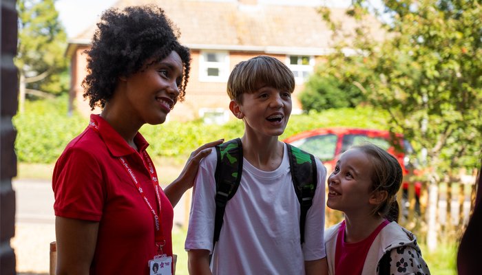 Social worker arriving on the doorstep with two happy foster children, smiling as they meet their first foster family - Smiling social worker at the door with two cheerful foster children, marking the moment a family welcomes their first placement - Soc