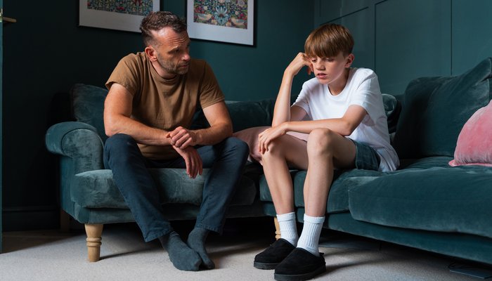 Foster carer offering therapeutic support, listening to a teenage boy during a difficult moment If you want it to lean more toward emotional safety, trust, or therapeutic care, I can shape a few more.