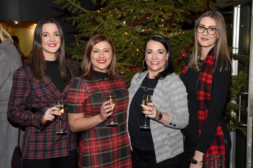 A group of woman smiling at the camera during the Big Braw quiz. They are wearing tartan clothes.