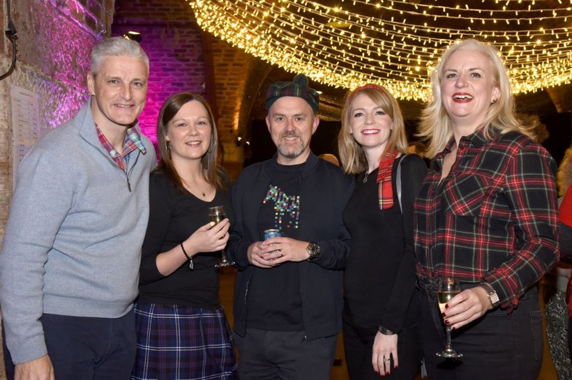 A group posing for a photo at the Big Braw quiz. They are wearing tartan clothes.