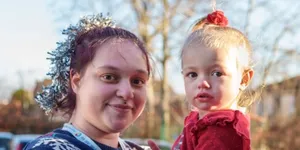 Woman holding little girl wearing a Christmas jumper