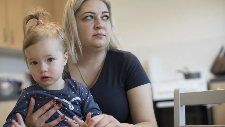 Mum Natalia and daughter sat at kitchen table