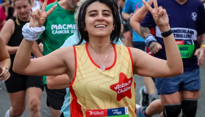 A runner participating in the Bath Half Marathon. They are wearing an Action for Children running vest.