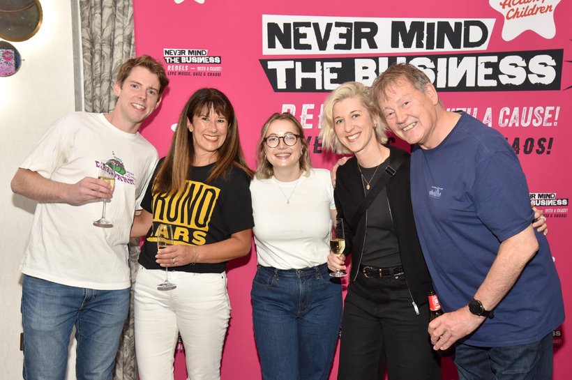 people gathered for a photo infrot of pink screen