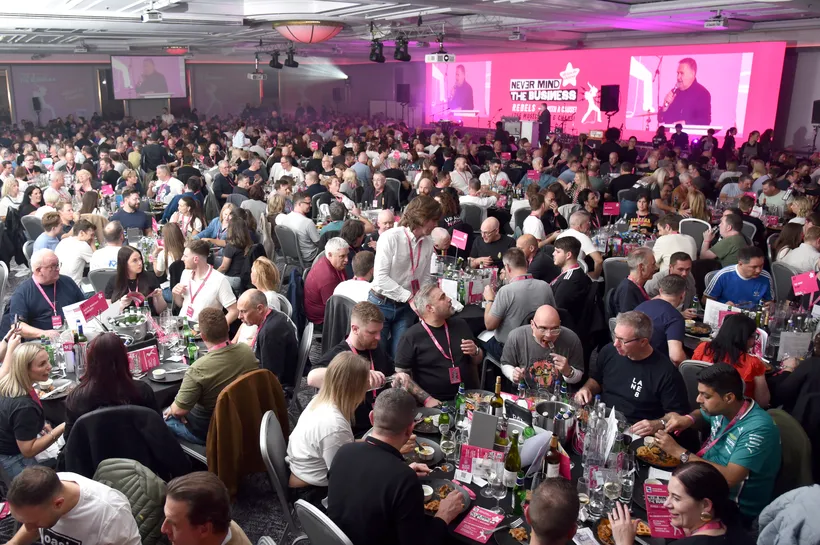 large room filled with people looking at a stage