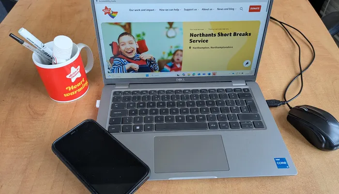 Picture of a laptop and mobile phone on a desk with Action for Children website on screen