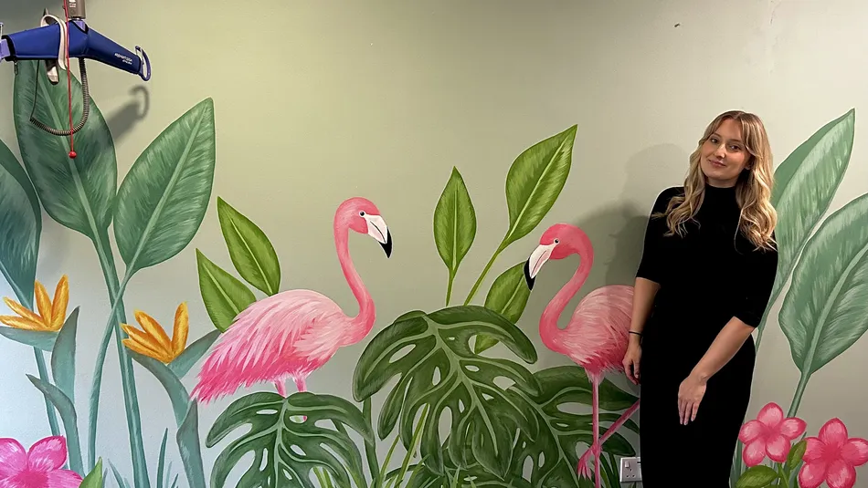 Emily Blythe standing in front of wall she has decorated
