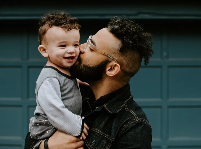 Father kissing toddler