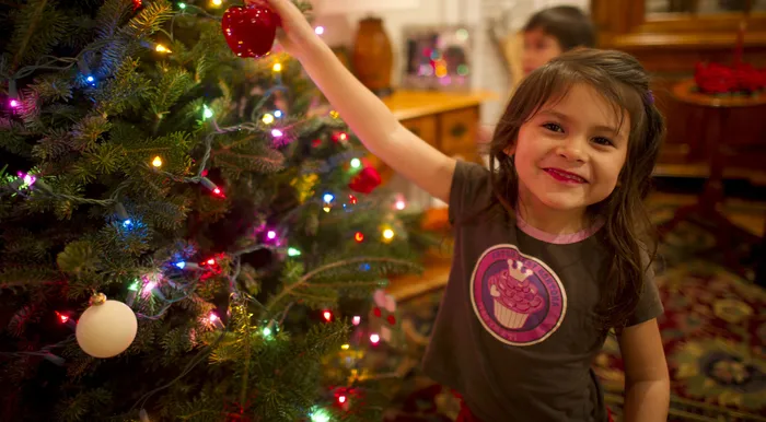 Little girl putting bauble on Christmas tree flipped.jpg