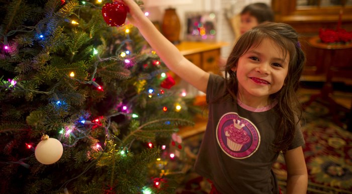 Little girl putting bauble on Christmas tree flipped.jpg