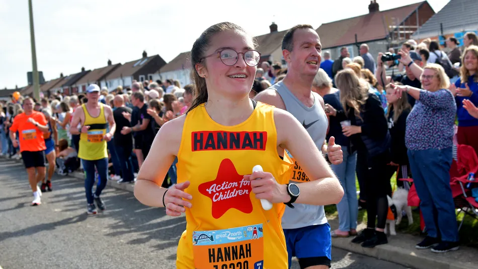 Hannah in a yellow Action for Children running vest at the Great North Run