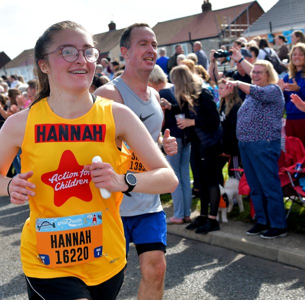 Hannah in a yellow Action for Children running vest at the Great North Run