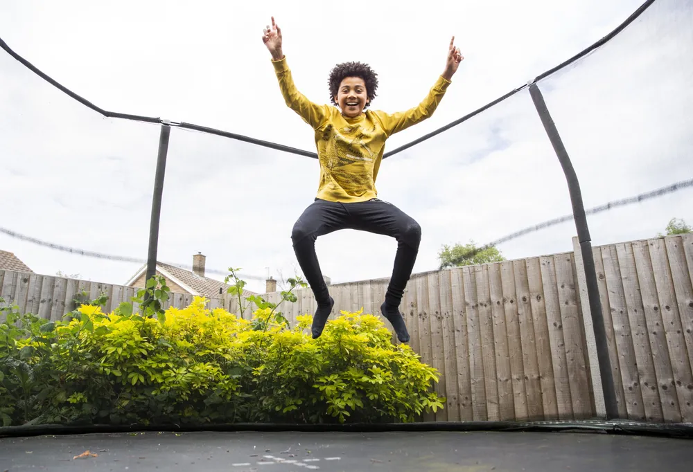 Happy boy jumping on trampoline