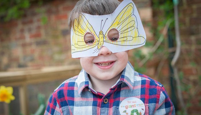 Happy boy with butterfly mask for Giant Wiggle
