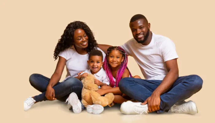 Happy mother and father with son and daughter hugging teddy bear in studio 2