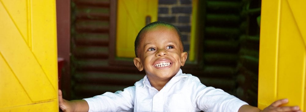 Happy young boy playing in wendy house