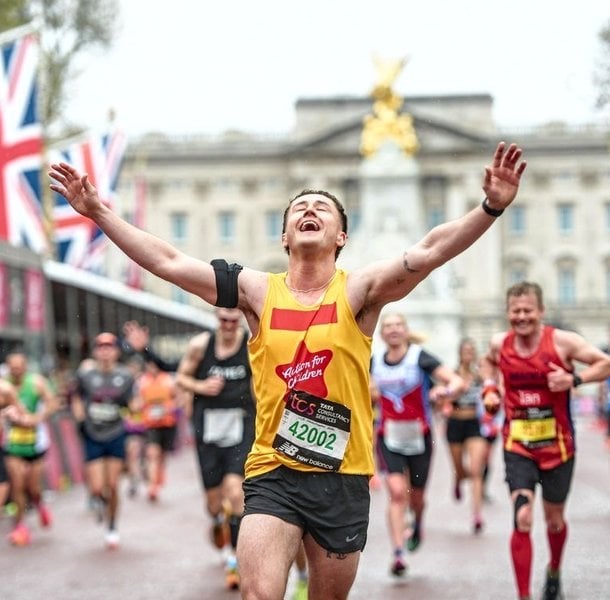 Joe crossing the finish line at the London Marathon, running for Action for Children