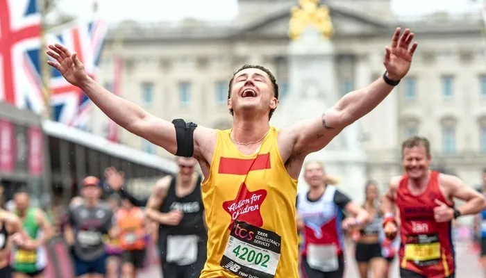 Joe crossing the finish line at the London Marathon, running for Action for Children