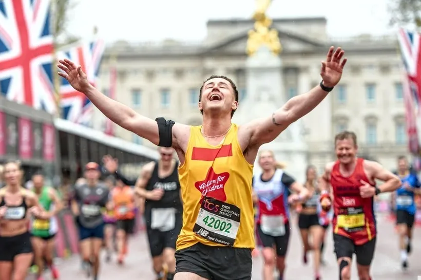 Joe crossing the finish line at the London Marathon, running for Action for Children