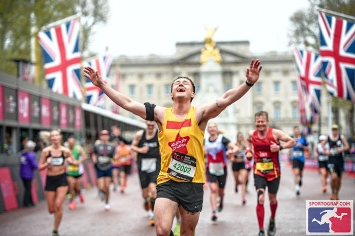 Joe crossing the finish line at the London Marathon, running for Action for Children
