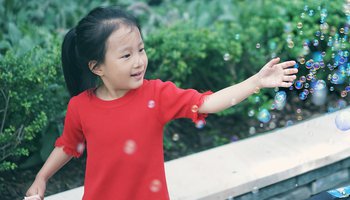 Little girl playing with bubbles