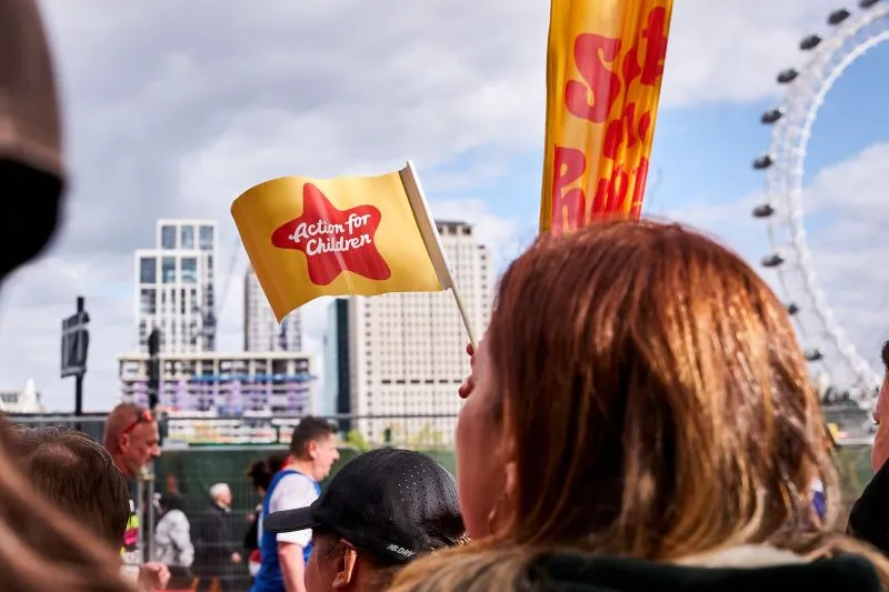 Action for Children flag waving against the London Eye at the London Marathon