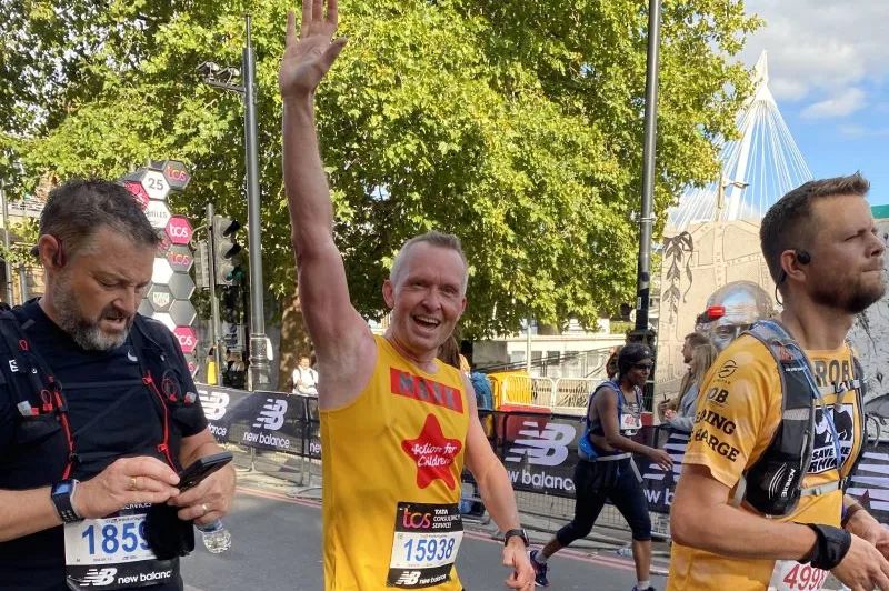 Action for Children runner waving at the the London Marathon