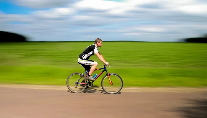 Man cycling along road with blurry background