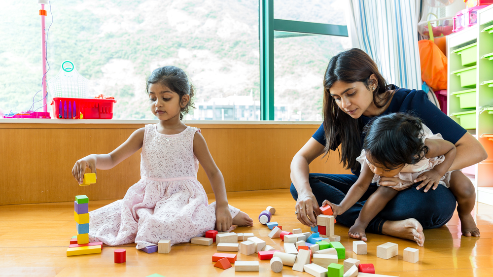 Mother and children together with play blocks.