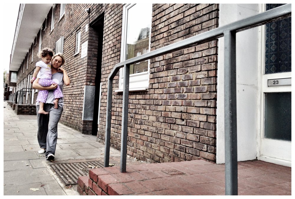 Mother and daughter walking outside council flats.jpg