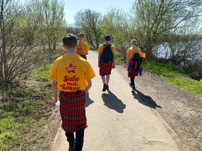 Group walking dressed in kilts and Action for Children T-shirts