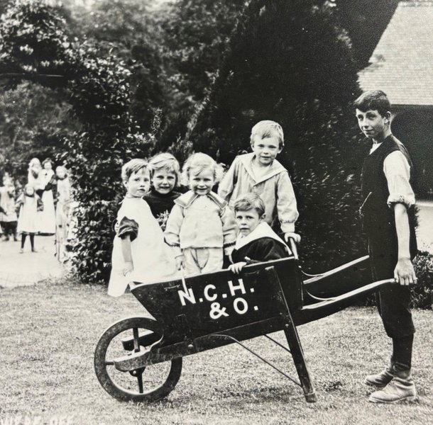Children in wheelbarrow at NCH home in Chipping Norton 1909