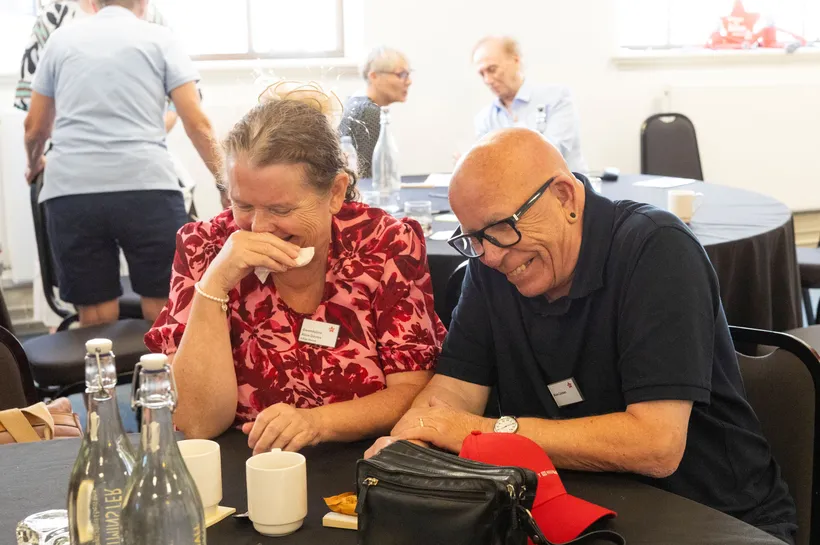 Two people sitting at a table and laughing together