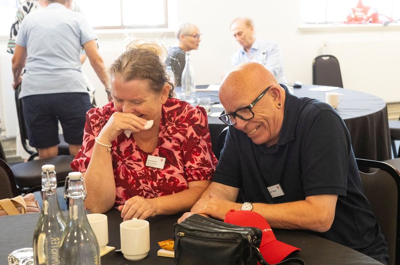 Two people sitting at a table and laughing together