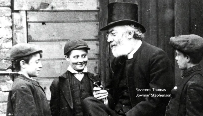 Reverend Dr Thomas Bowman Stephenson talking to three young boys