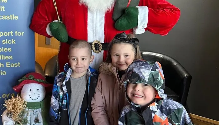 Happy children standing in front of Santa Clause