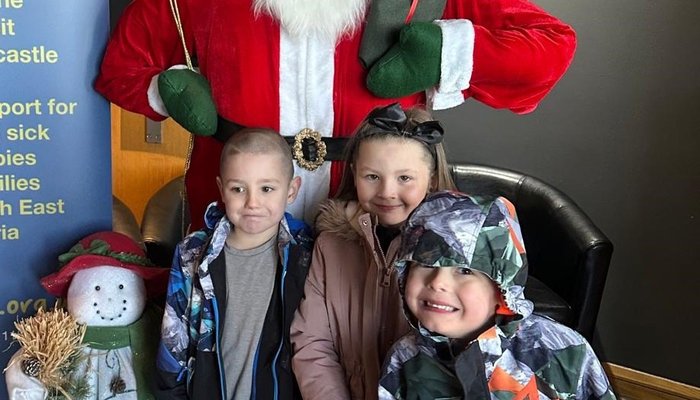 Happy children standing in front of Santa Clause