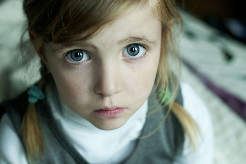 Sad young girl looking up