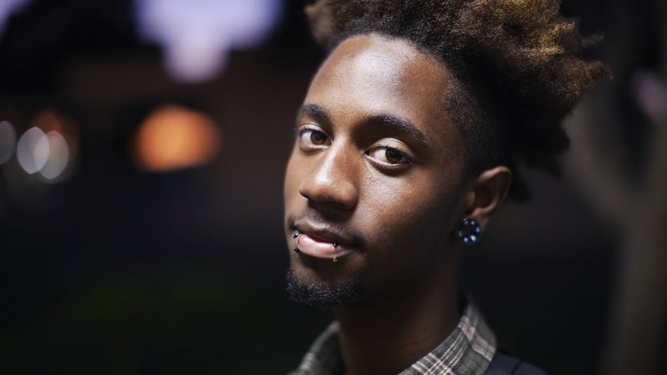 Serious looking teenager with piercings posing for the camera