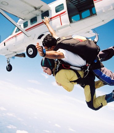 Skydivers exiting plane in the sky