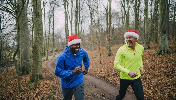 Sporty Santa Campaign - two men running in the forest with secret santa hats