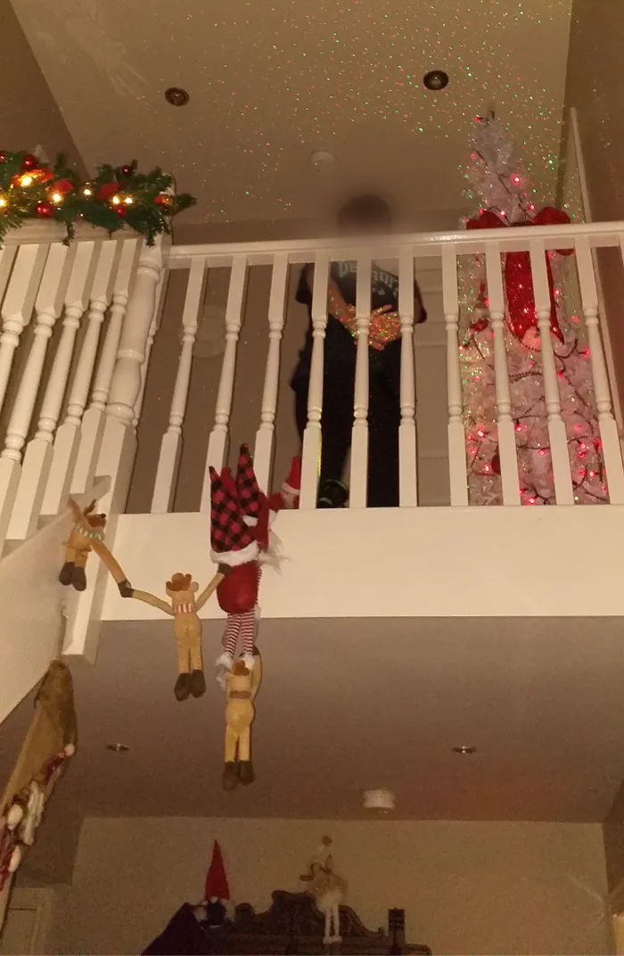 Staircase decorated for Christmas, a young boy is at the top of the stairs