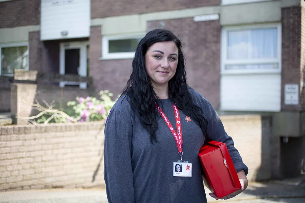 Action for children support worker holding shoe box