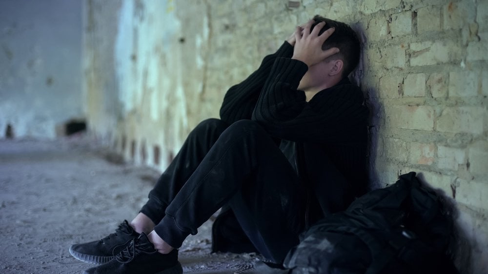 Teenage boy hiding in abandoned building